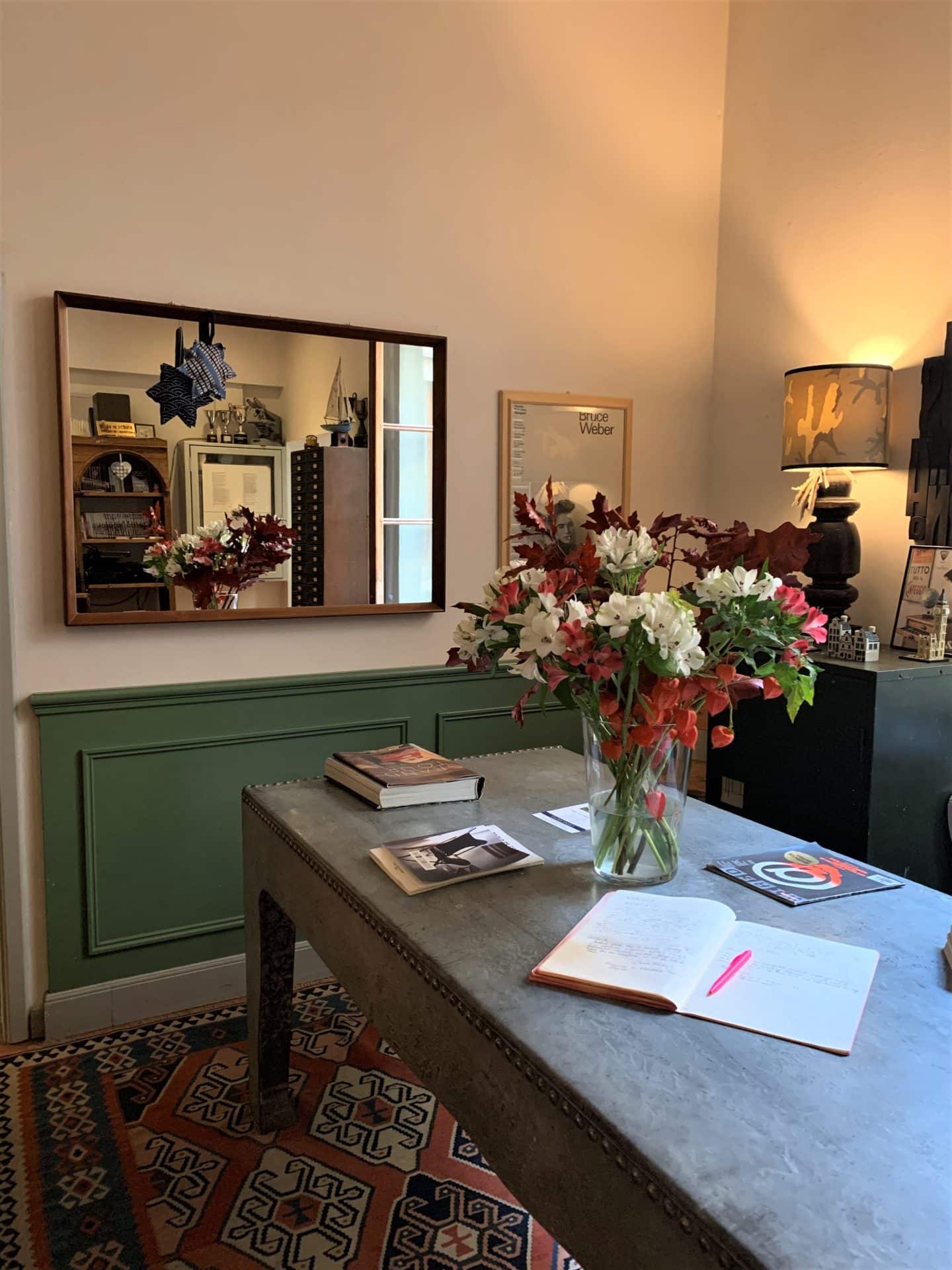 mirror with reflection of table and flowers in reception area