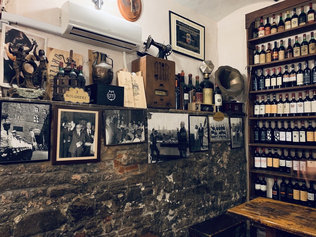 Osteria Nuvoli - bottles of wines and photos in the cellar room of the bar