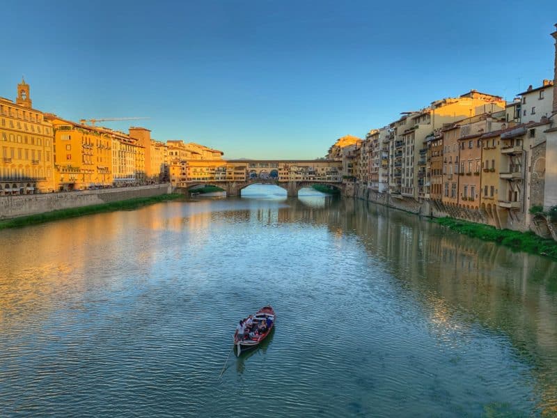 Oltrarno An Artisanal Neighbourhood in Florence: a rowing boat going down the River Arno with the Ponte Vecchio in the background