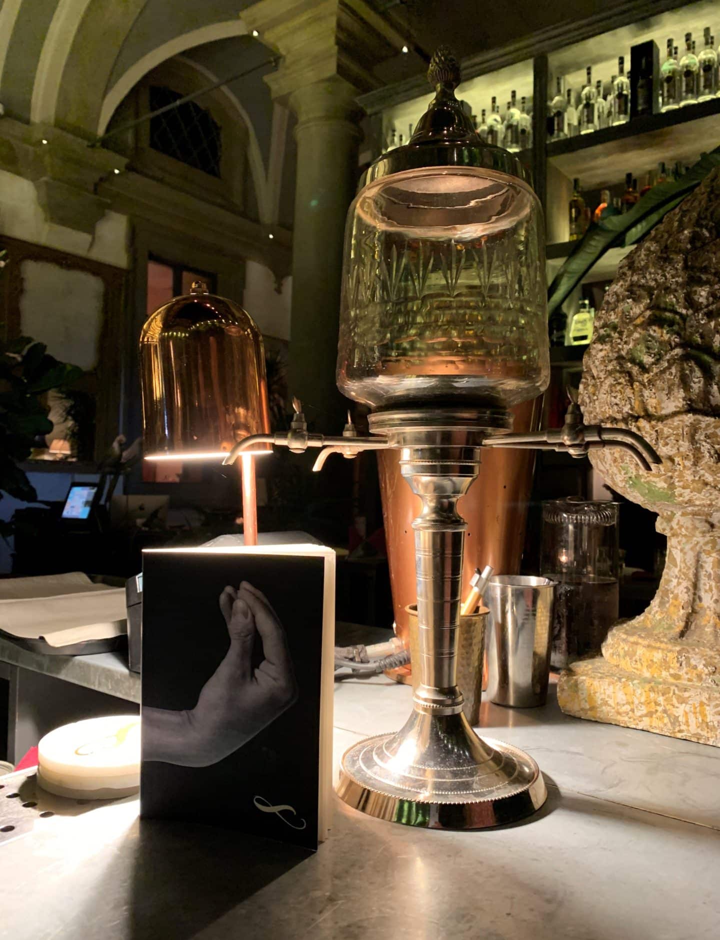 Il Locale - The bar area with a menu and a gold lamp in Florence.