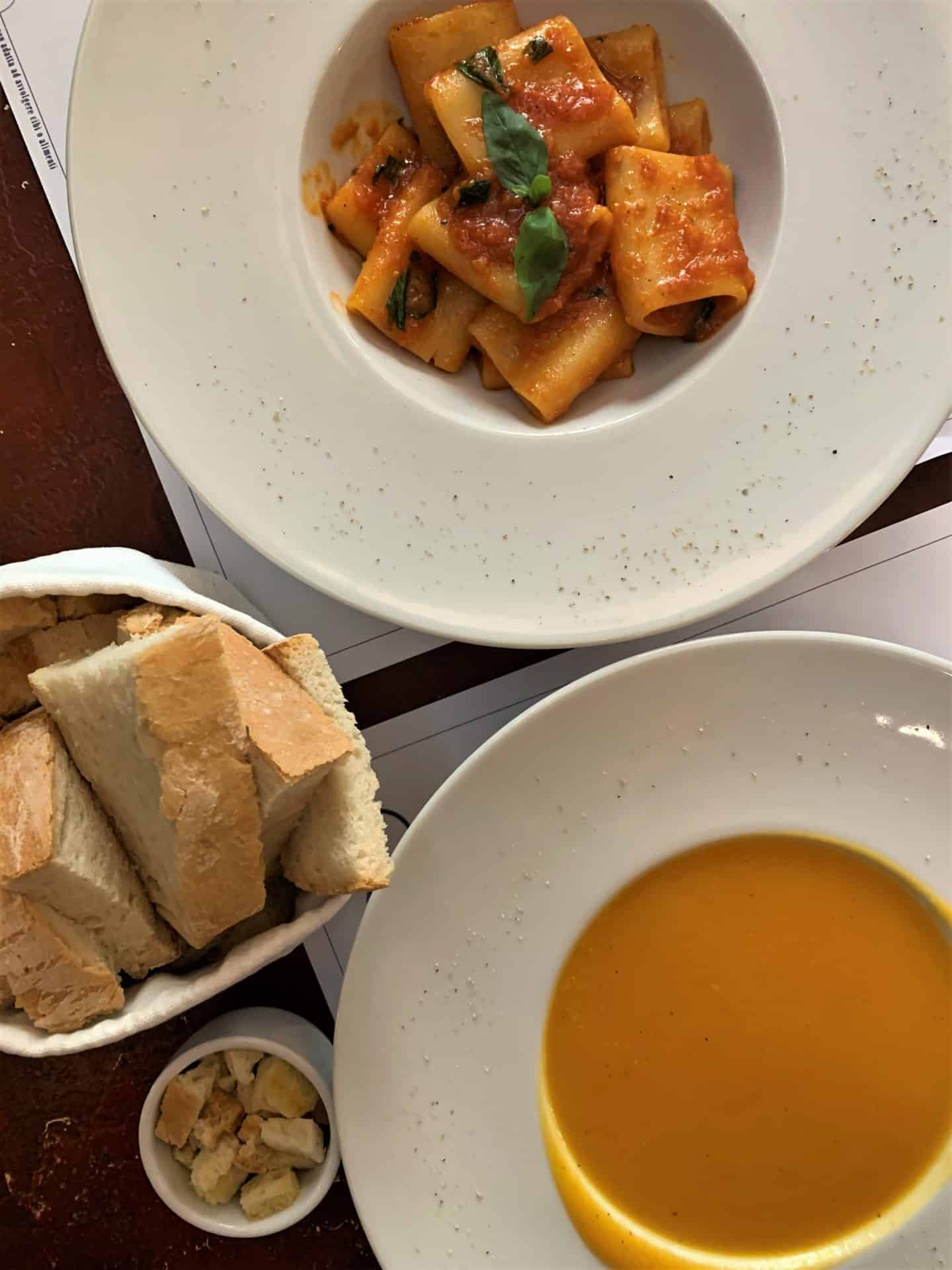 Ravioli with tomato sauce and a bowl of pumpkin soup with a bowl of bread. Vegetarian-friendly food in Florence.