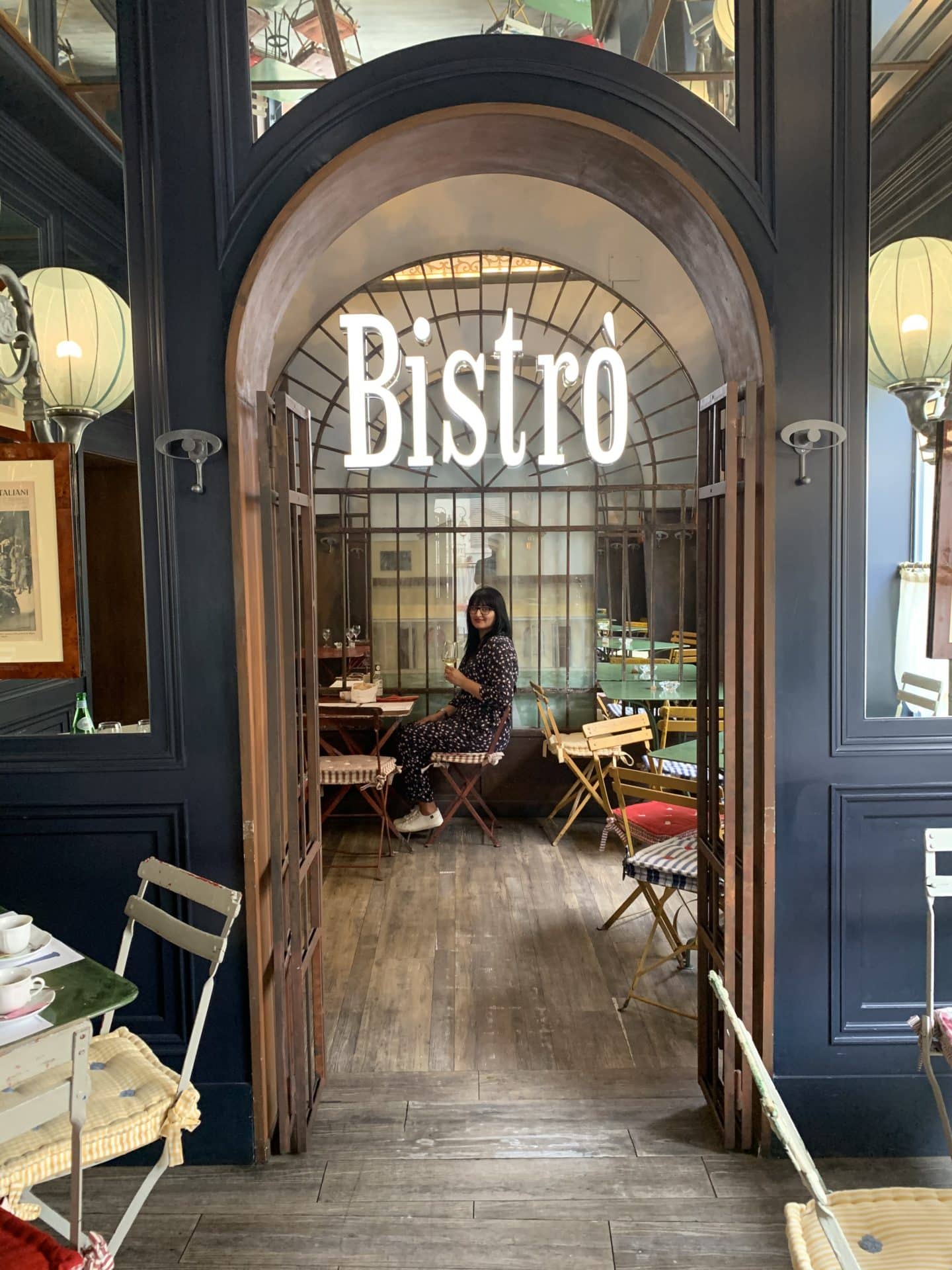 Bejal sitting in Bistrot Cafe 1926 with door archway and 'Bistro' written on the door.