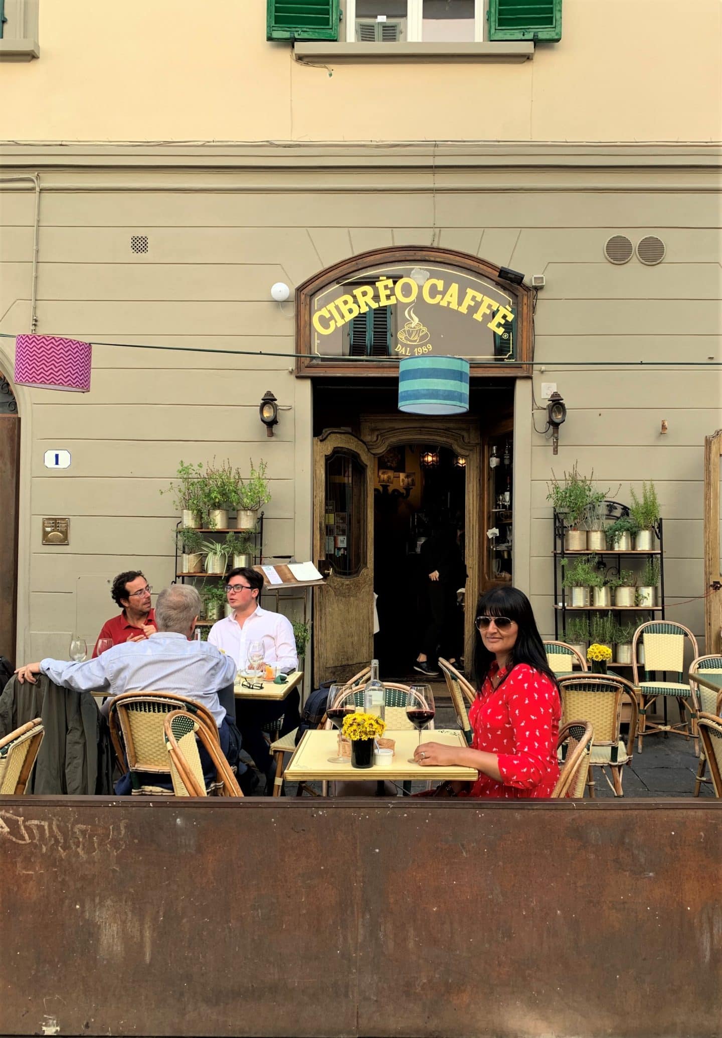 Cibrèo Caffè - Bejal wearing red dress and sitting on table eating food outside the restaurant