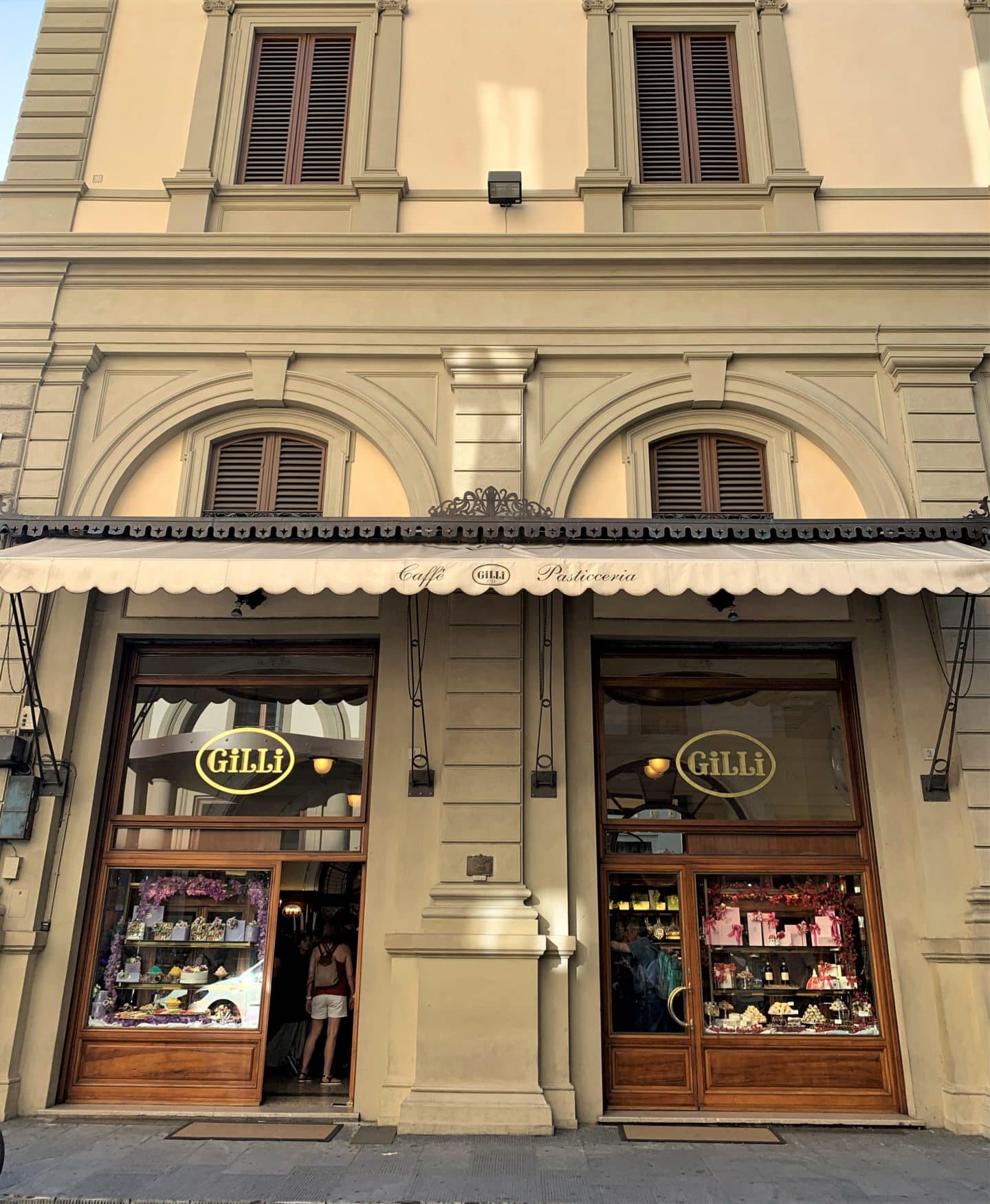 Vegetarian-friendly food in Florence. The exterior of Caffè Gilli with tall brown windows, awning adn brown 2windows