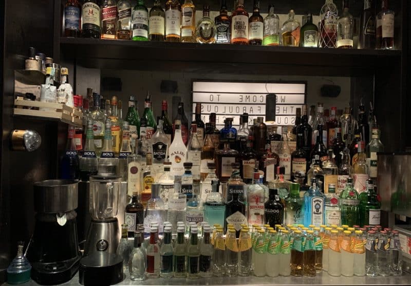 Mezcal Gingerita and Chilicano bar area with bottles of alcohol adn spirits in the background.