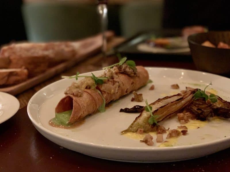 Vegetarian-friendly food in Florence. vegetarian cannelloni with a green pea sauce on a white plate at Konnubio Restaurant. 
