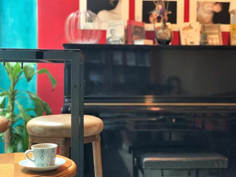  Oltrarno An Artisanal Neighbourhood in Florence: an espresso coffee with a piano in the background at Libreria Café La Cité