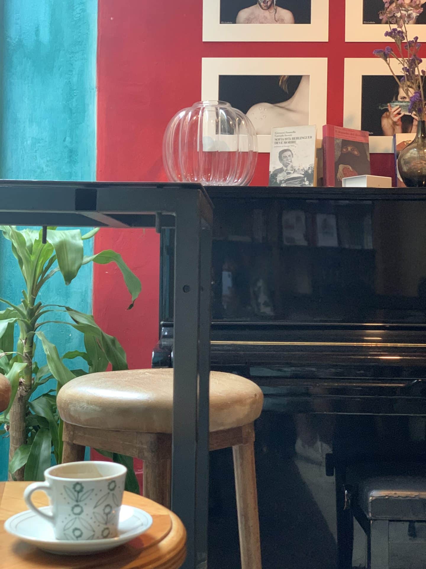Libreria Cafè La Cité, the piano with a cream stool and a cup of half drunk coffee. 