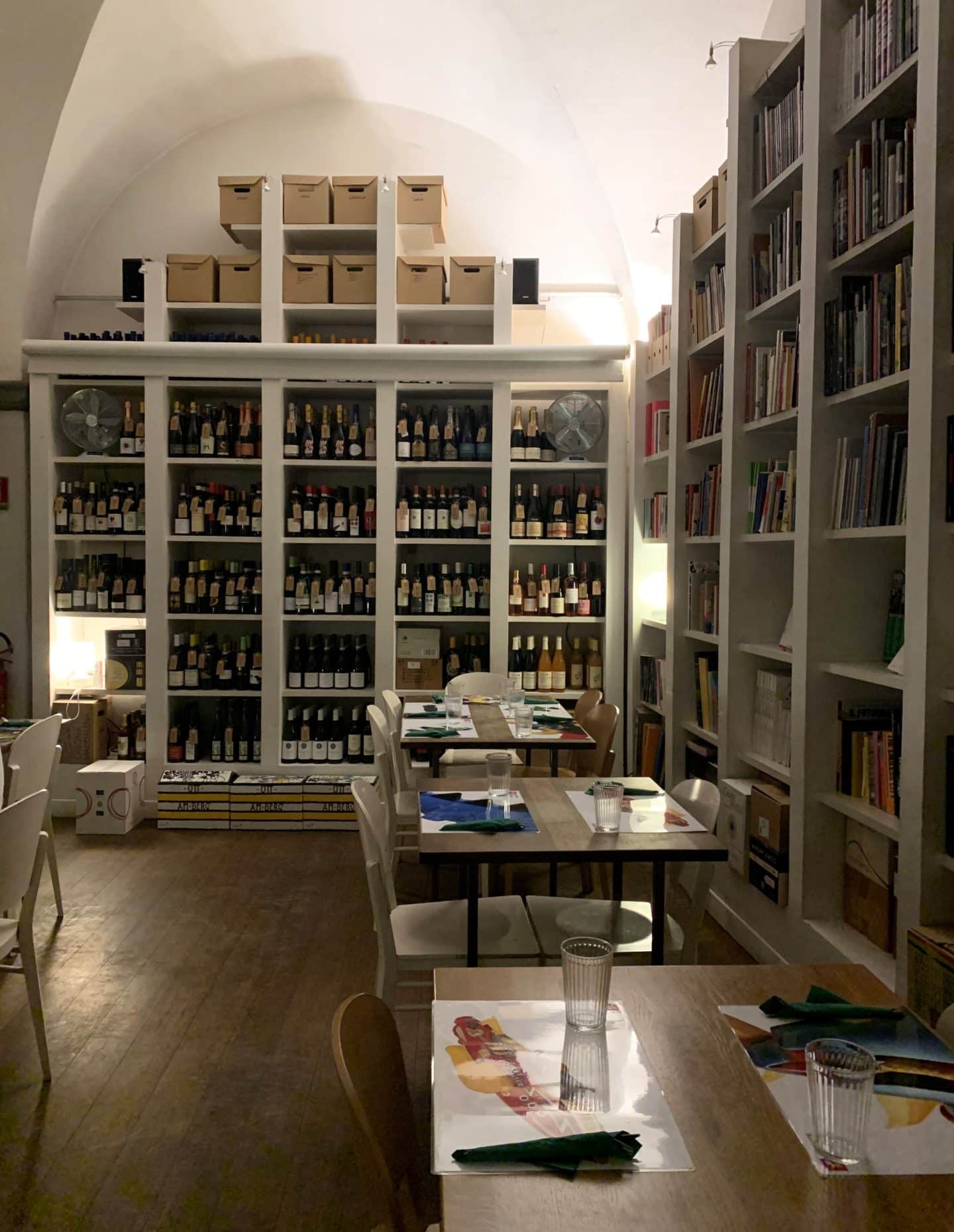 The interior book cases in BRAC with wine bottles and books and dining tables.