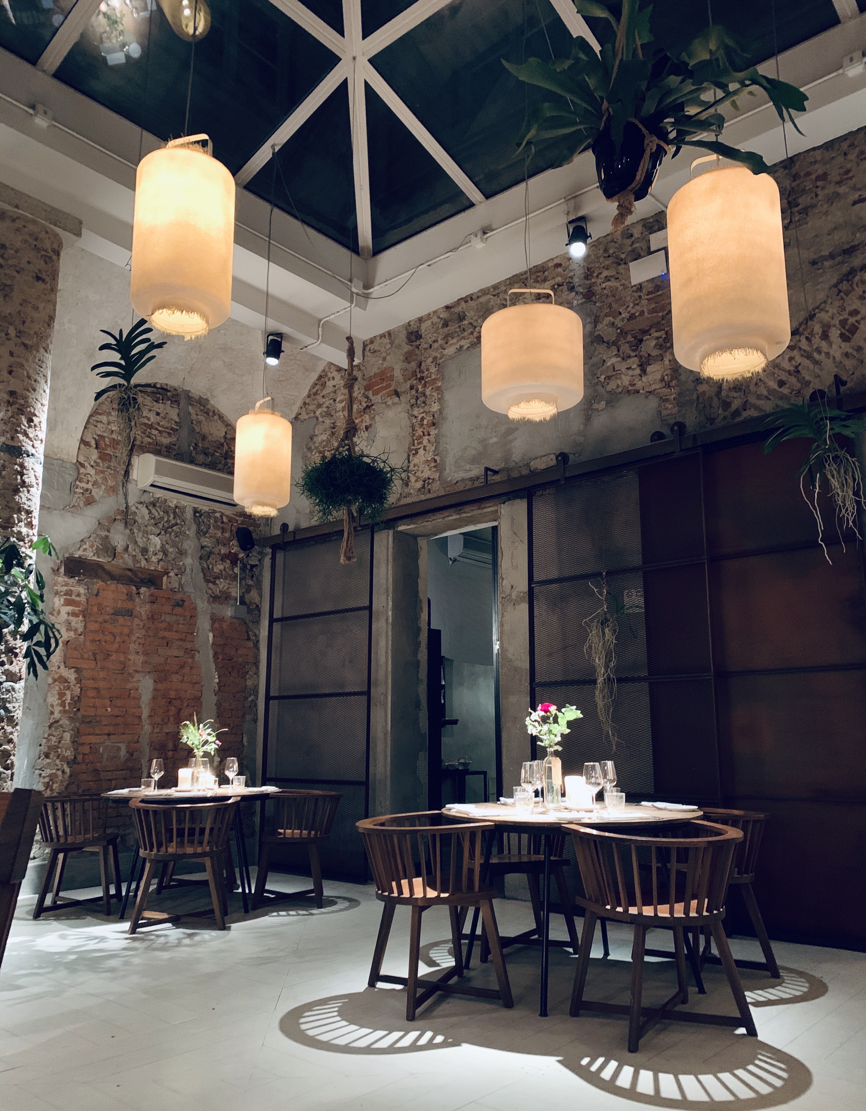 La Ménagère - Interiors of restaurant with long white lights. Stone work and arches of restaurant