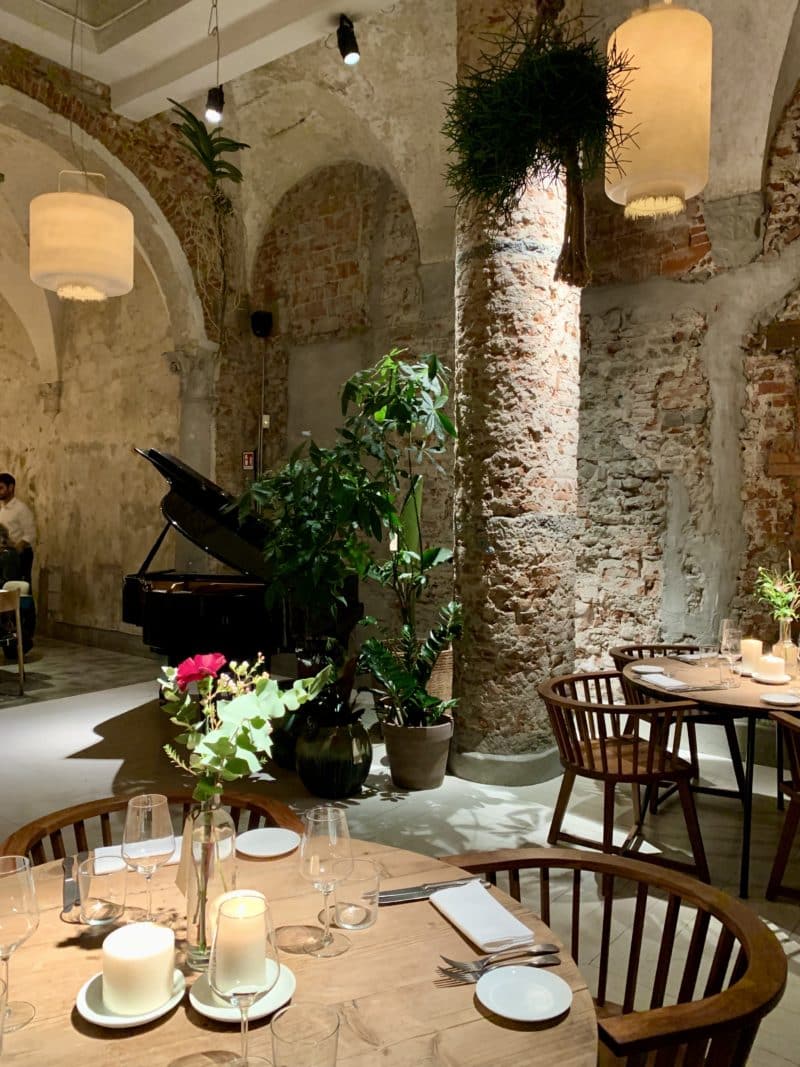 La Ménagère - Interiors of restaurant with long white lights. Stone work and arches of restaurant