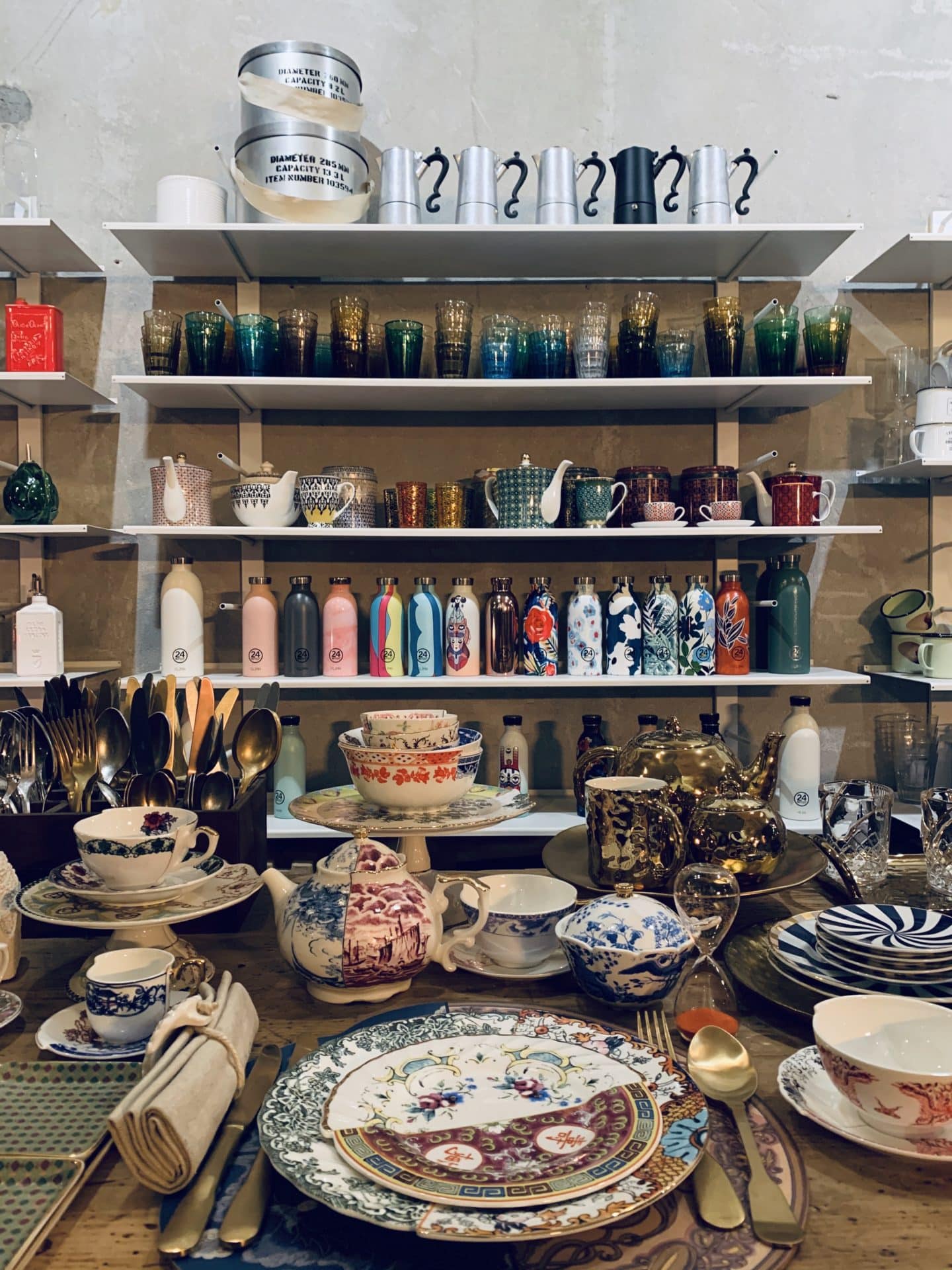 La Ménagère  plates and saucers with cups on shelves at back