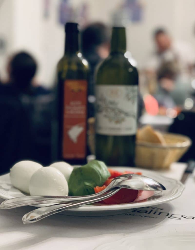 Trattoria La Casalinga - mozzarella, tomatoes an basil salad with olive oil and balsamic vinegar in the background.