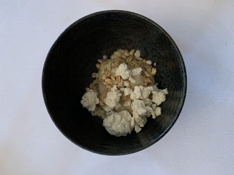 Risotto of Toasted Grains, Oxtail and Stichelton in a black bowl