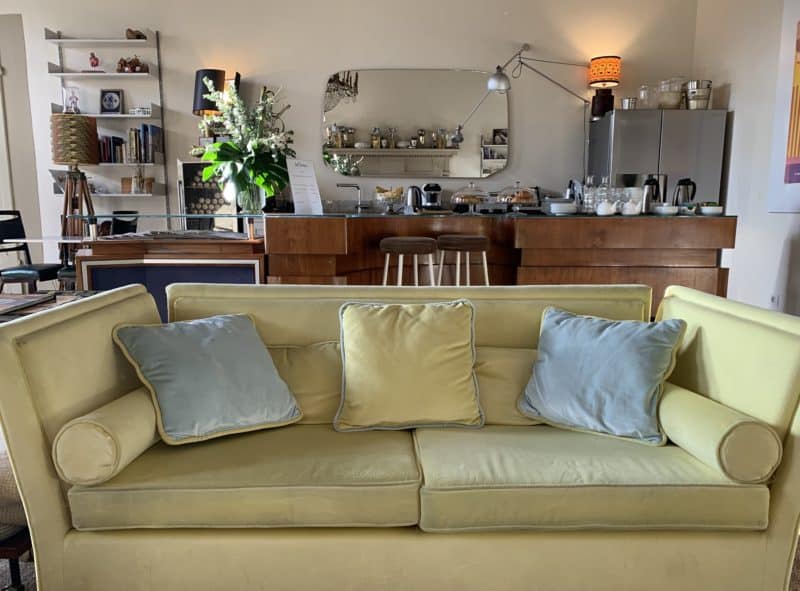 AdAstra Florence: yellow comfy couch with breakfast and snack bar at back