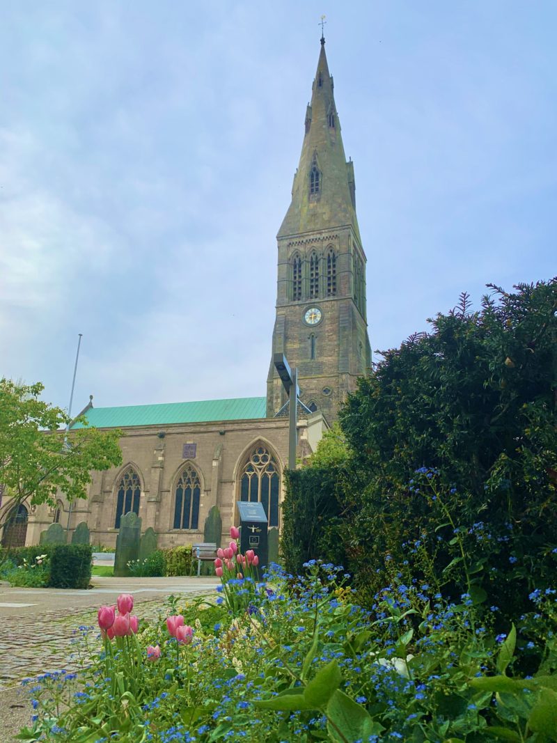 Leicester Cathedral in the springtime surrounded by tulips and wild flower bushes