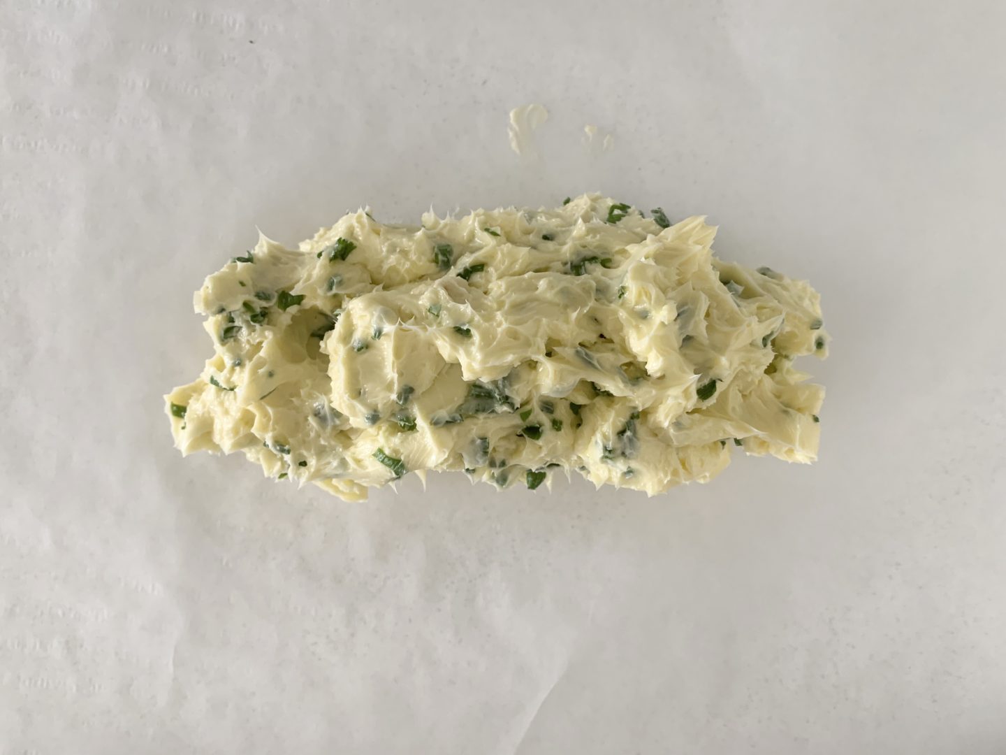Melted butter, chives and salt mix on greaseproof paper