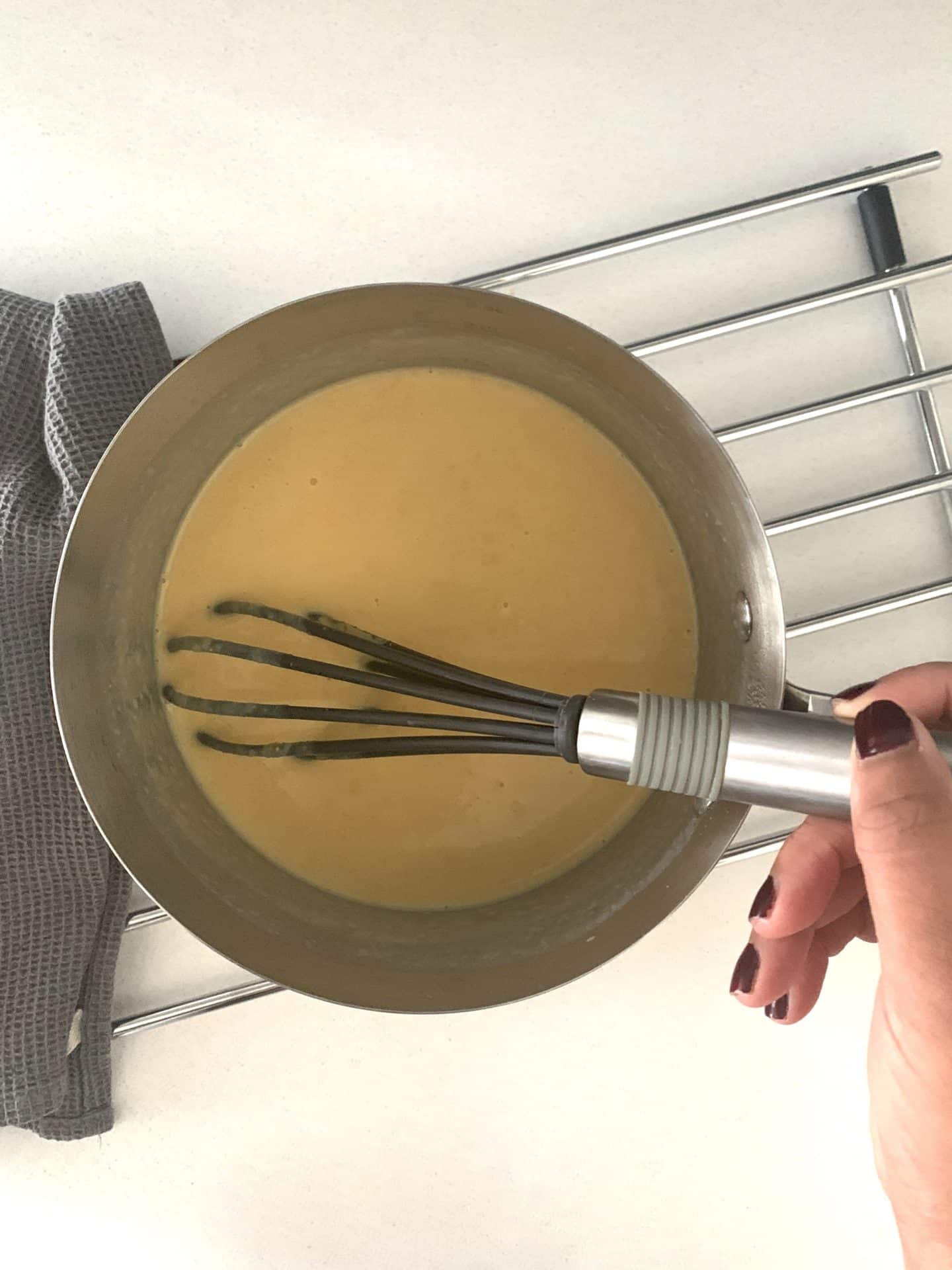 Making the cheese sauce for the cauliflower dish with a whist