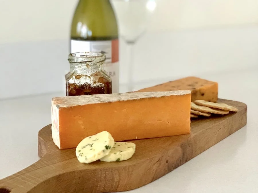 Red Leicester Cheese board with wine bottle and garlic butter with biscuits