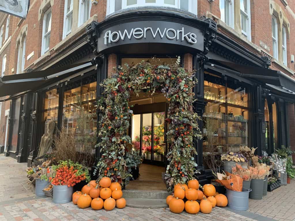 Autumn display at Flowerworks florist in St. Martin's Leicester. There are pumpkins and a orange and autumn foliage arch around the black entrance way.