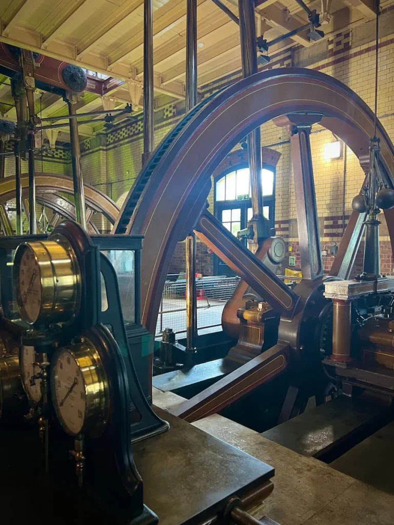 One of the engines at Abbey Pumping Station with small gold clocks and wooden flooring