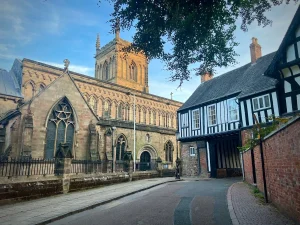 St. Mary de Castro Church entrance near Castle View with Tudor black and white building to the right and trees framing the photo in Leicester city Centre