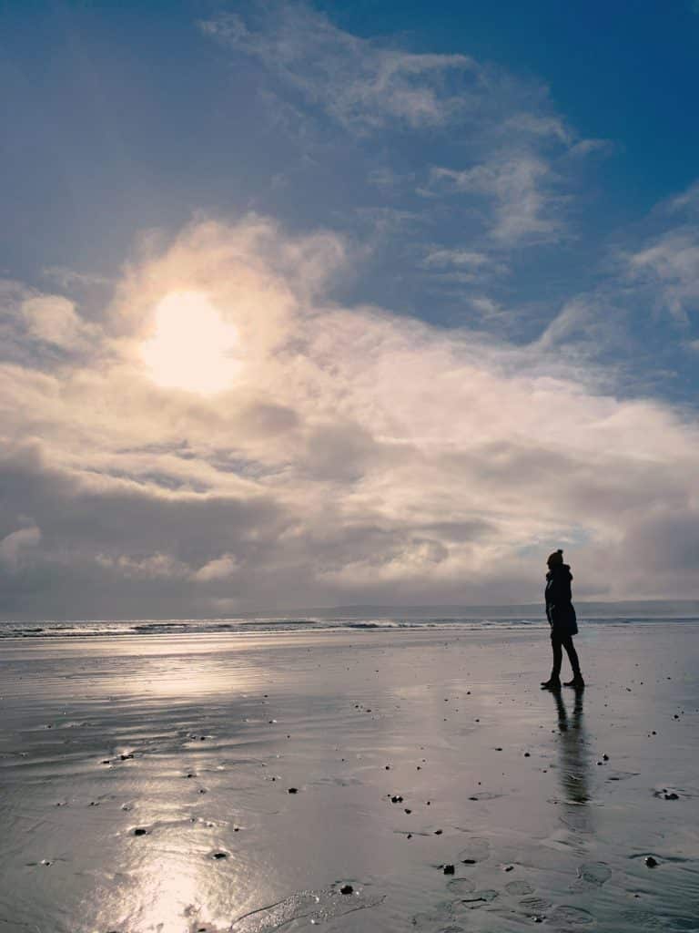 Bejal standing on Filey beach with the low clouds and tide out
