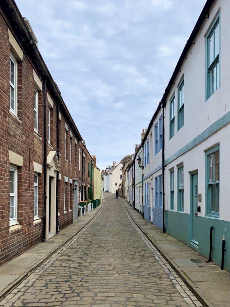 The famous cobbled stoned Henrietta Street in Whitby with its whitewashed blue terrace fronted houses