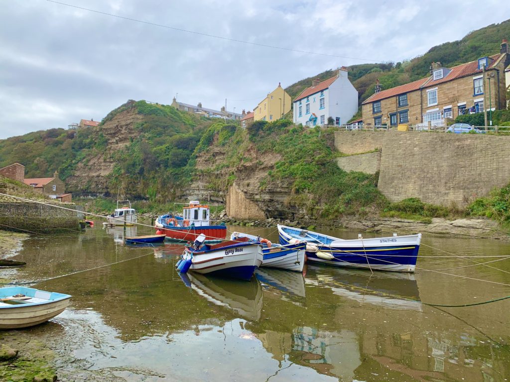 Staithes fishing boats in the small bay with houses at the top of the hill