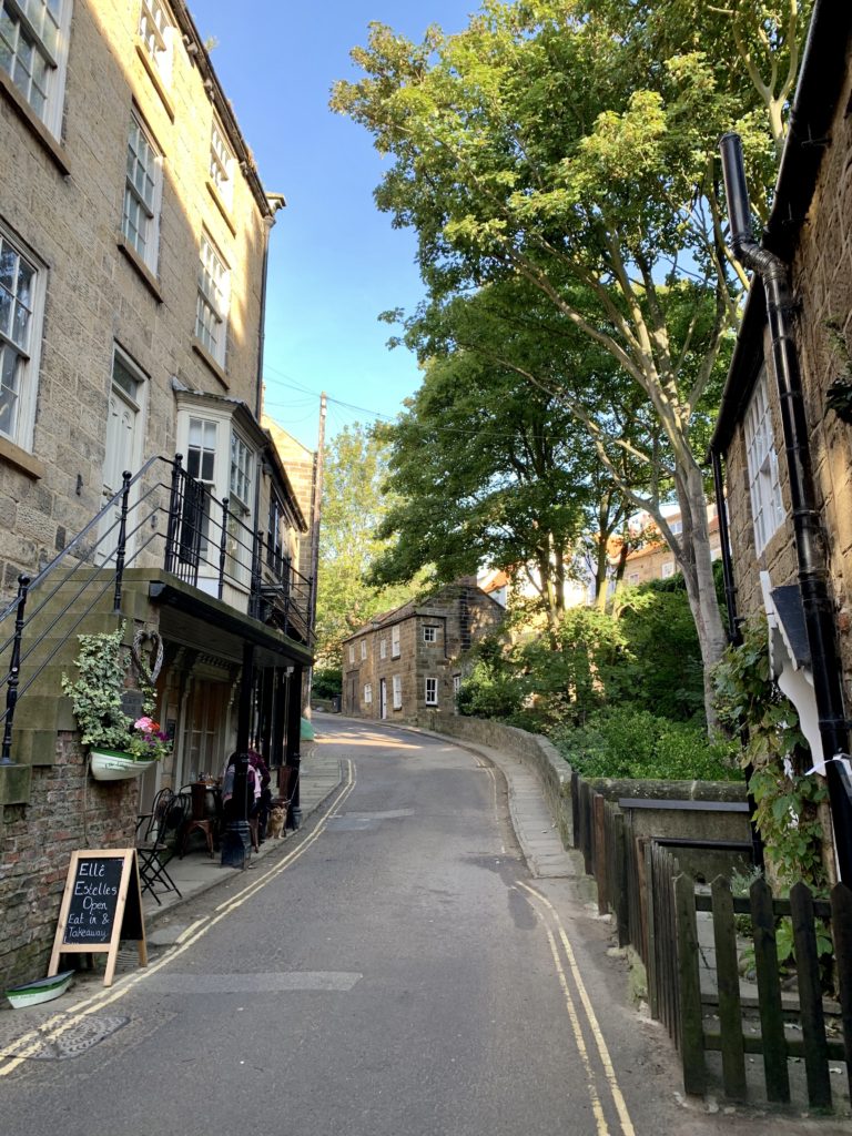 Robin Hood's Bay street with an incline adn shops at either side
