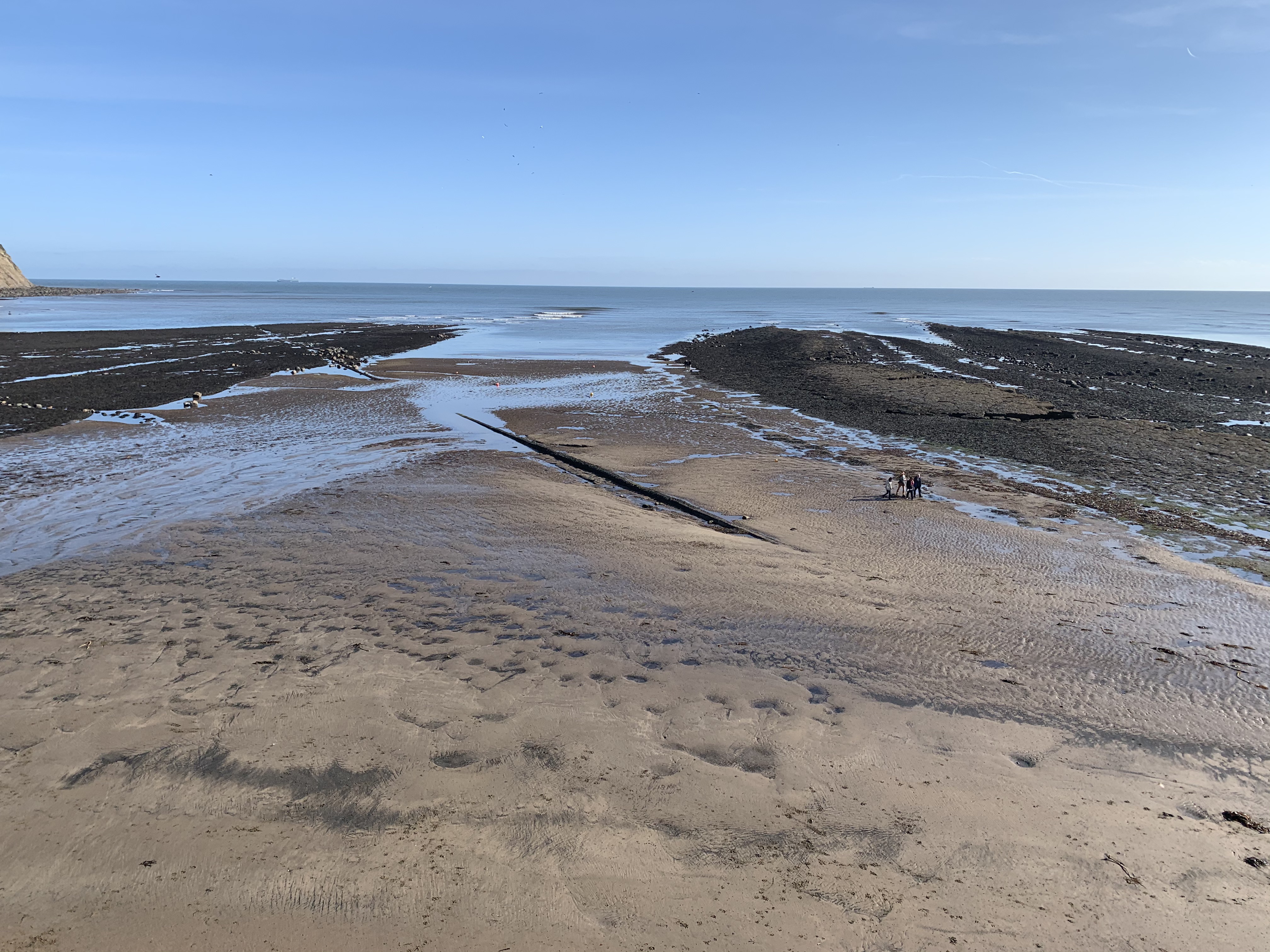 Robin Hoods Bay rock pools with sand and blue skies