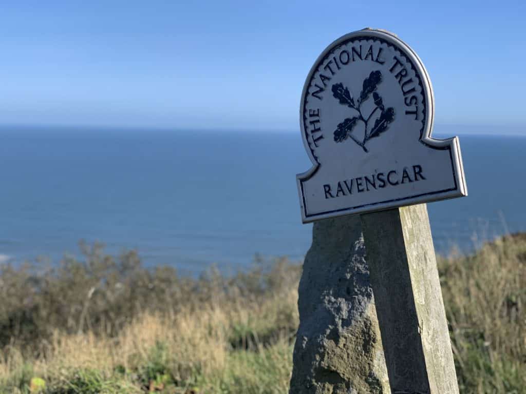 Ravenscar National Trust sign with the sea in the background