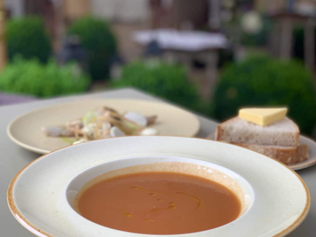 Red Pepper Soup in a large white bowl with bread and butter in teh background at The Wiveton Bell, Norfolk