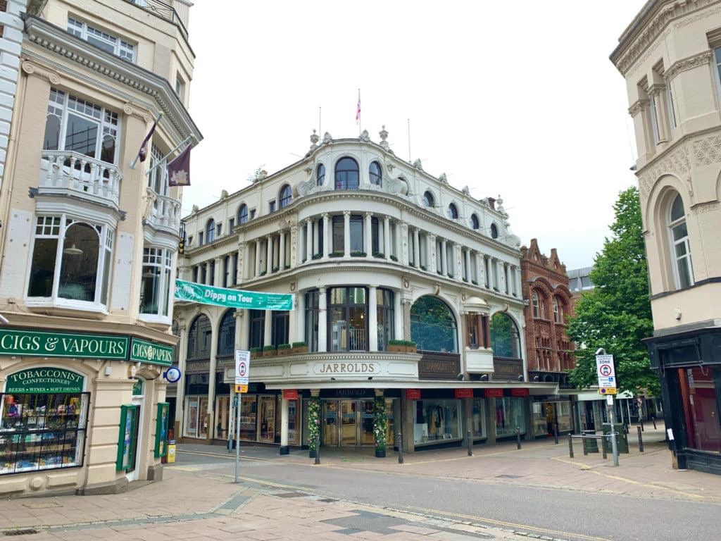 The exterior of Jarrold Department Store in Norwich. There are other buildings at either side with a grey sky in the background.