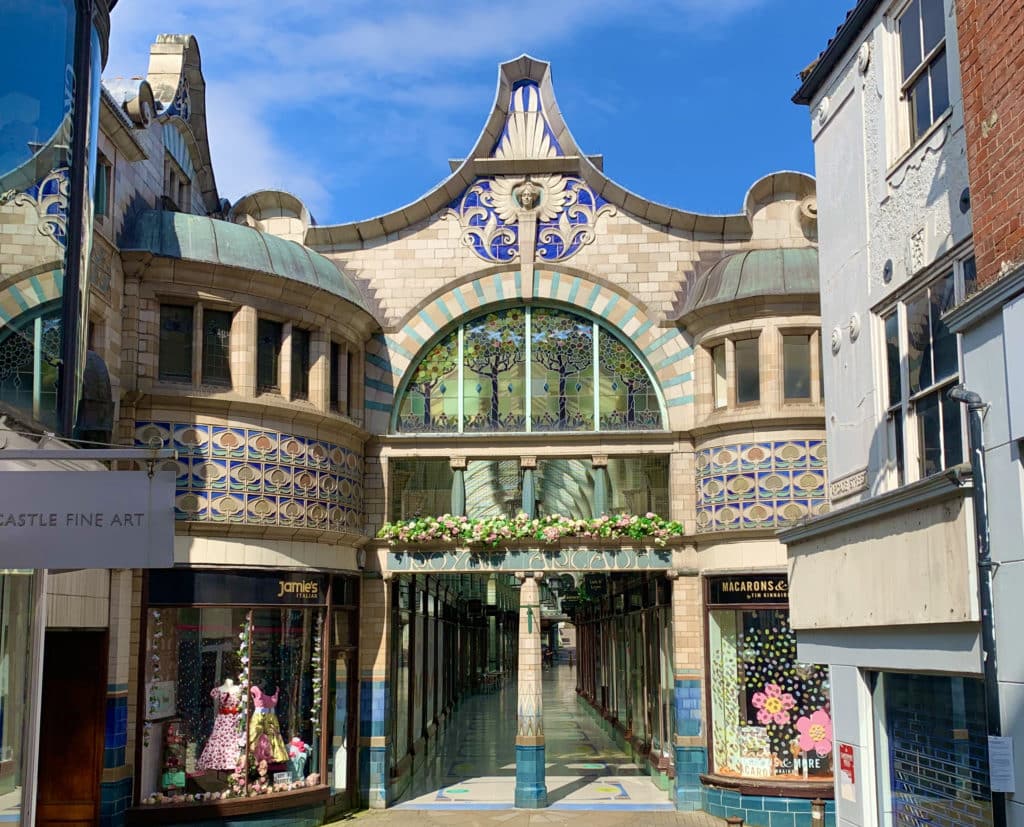 The ornate entrance of the Royal Arcade, Norwich. The exterior is decorated with blue. and yello tiles.w
