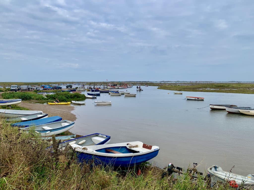 Morston Quay fishing boats in different colours with marshland in the background, Norfolk