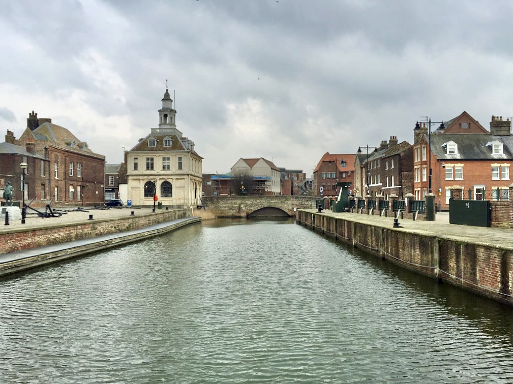 King's Lynn harbour with the river in the centre and old buildings on either side.