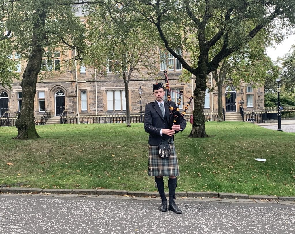 48 hours in Glasgow, a Bag Pipe Player wearing teh traditional dress of kilt near the Glasgow university grounds.