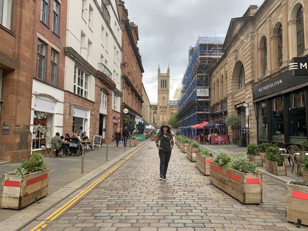 48 hours in Glasgow: bejal walking down a street in Glasgow City Centre wearing black dungarees and shops on either side