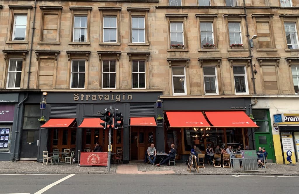 48 hours in Glasgow: The exterior of  Stravaigin in Glasgow with its dark grey walls and red awning