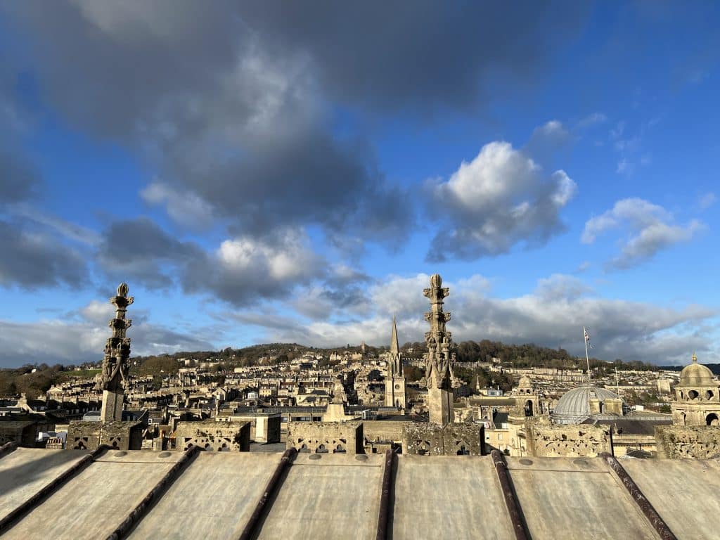 Bath Abbey Rooftop views of the city's historical buildings with blue skies and dark grey and white clouds