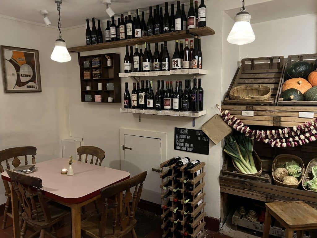Shelving with wine bottles and grover area of store at Oak Restaurant Bath