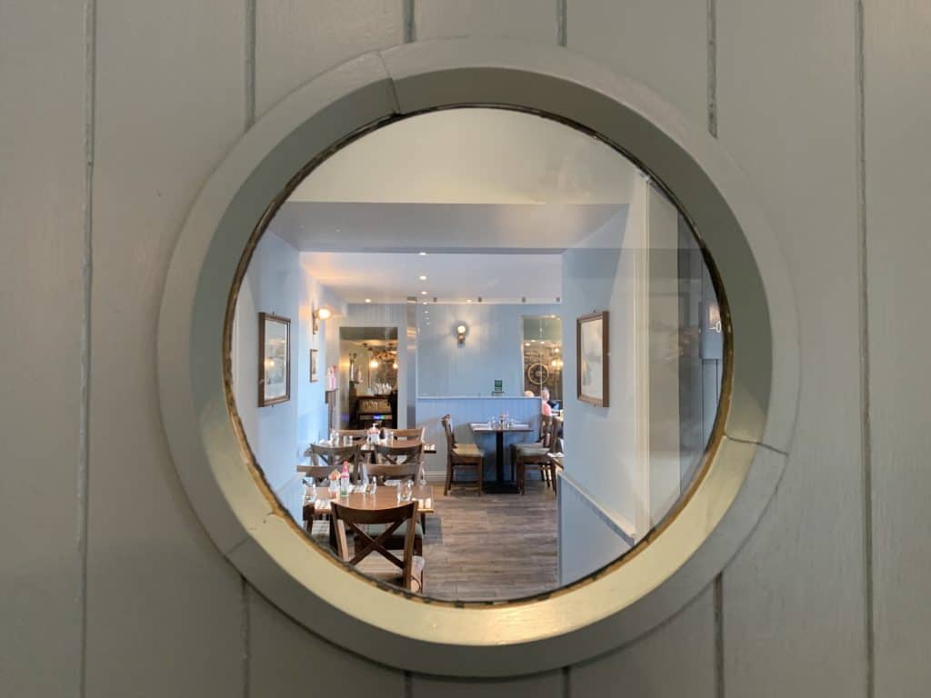 The Ship Inn Restaurant in Elie with a circular window where guests can see into the restaurant