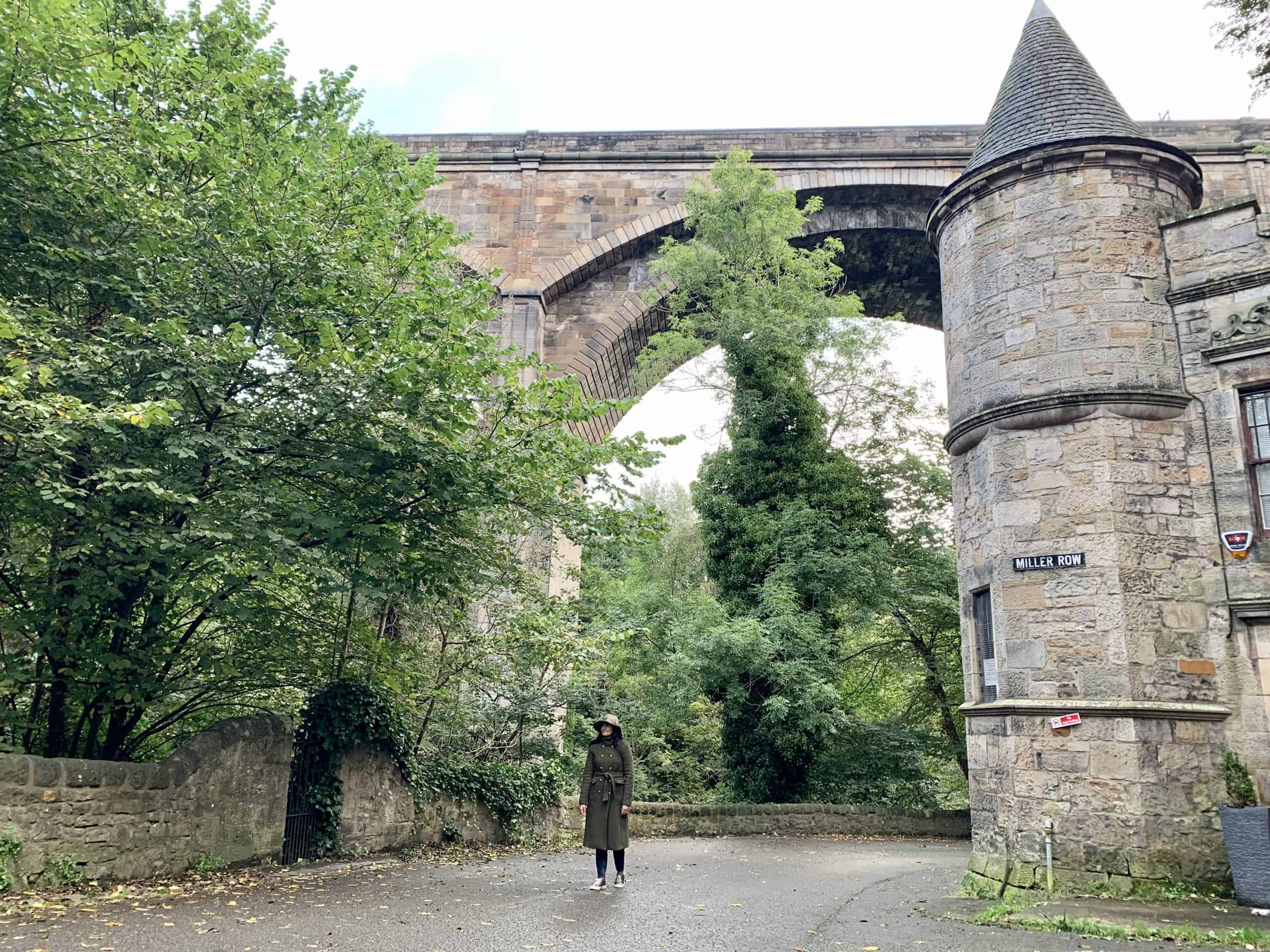 Water of Leith Walkway: bejal walking under bridge with trees on either side
