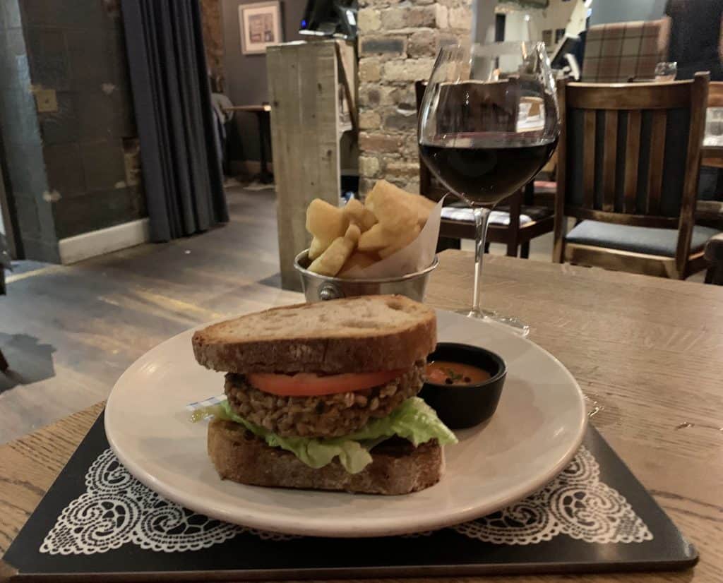Scran & Scallie, Edinburgh. Vegetarian burger with lettuce adn tomato with chips and a glass of red wine. Located in Edinburgh