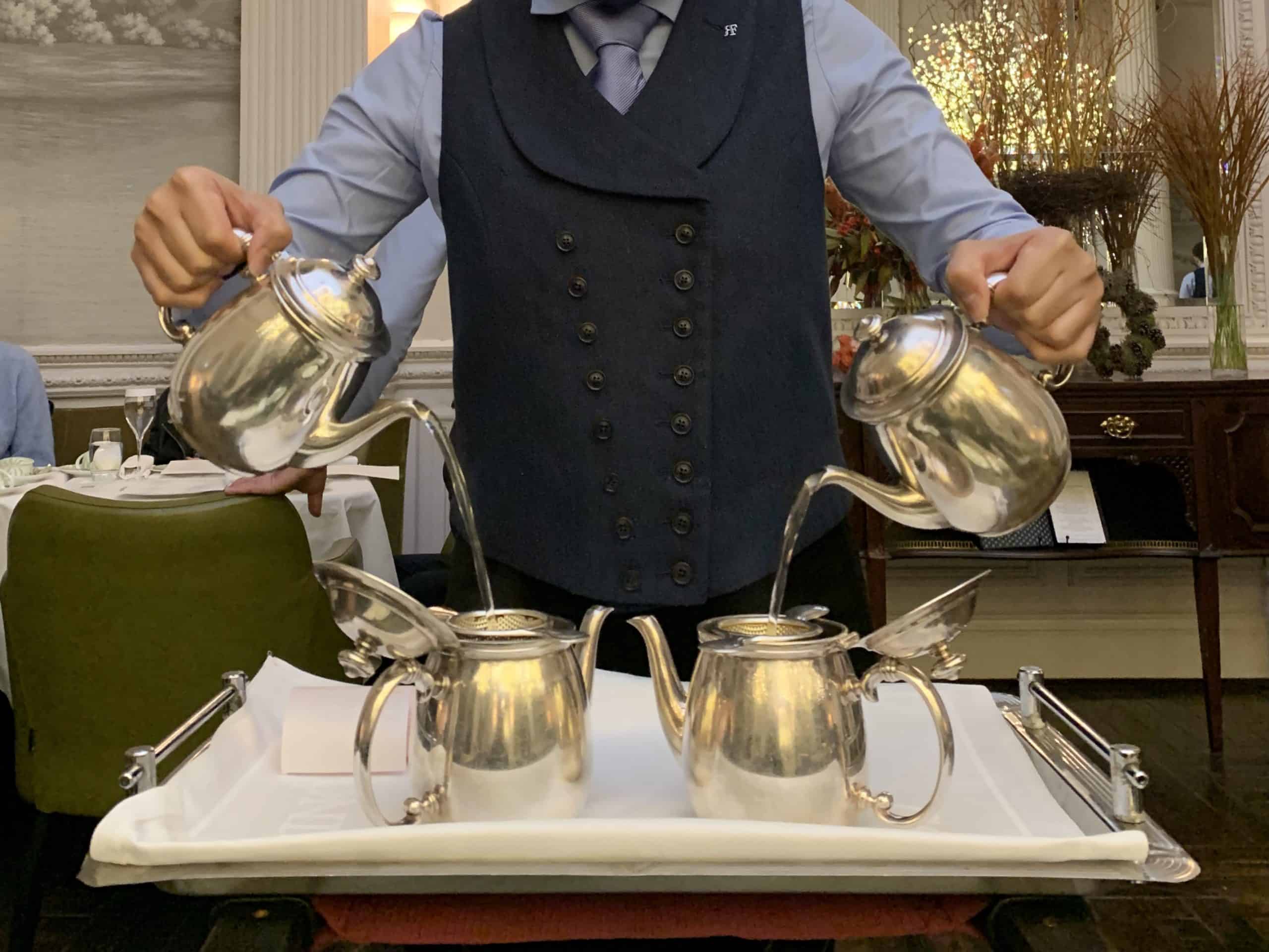 Balmoral Afternoon Tea where waitress is t pouring tea with both hands into a silverware pot. Located in Edinburgh