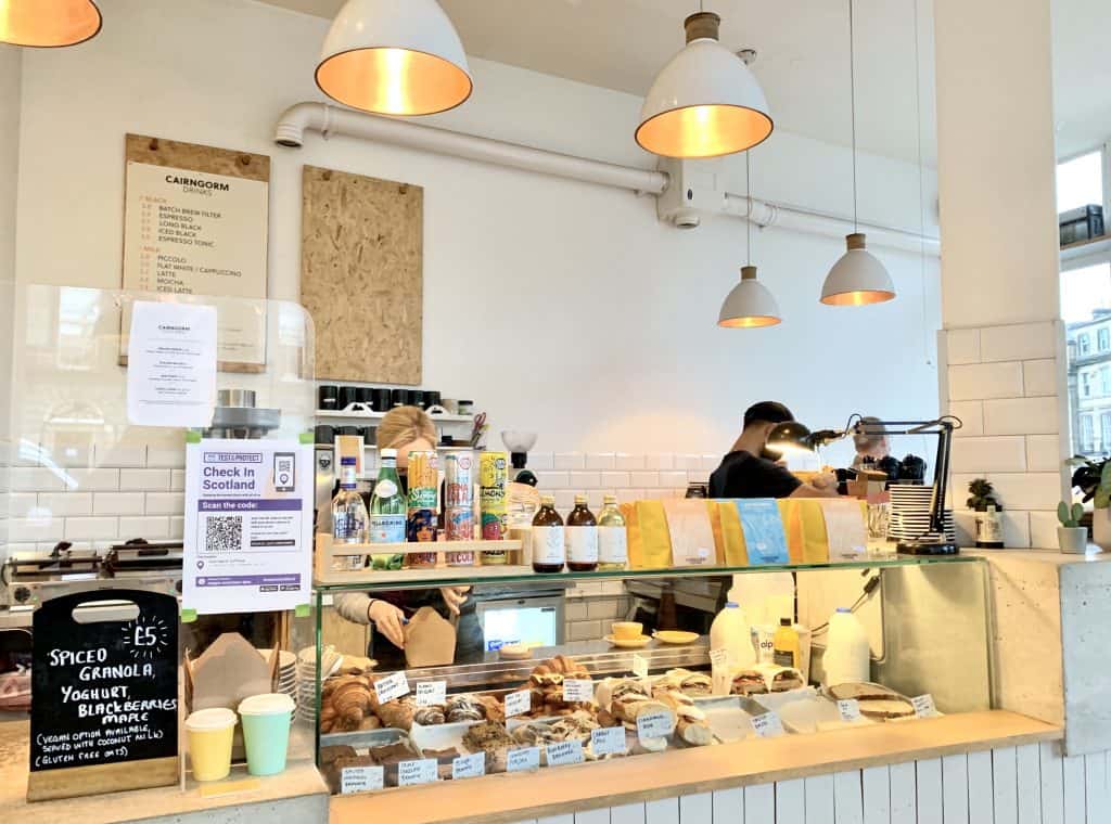 Coffee Cairngorms, Edinburgh with staff making coffee and counter with cakes and pastries. Located in Edinburgh