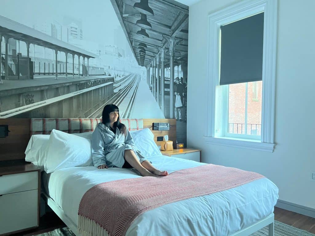 Bejal sitting on on bed in Loft Suite