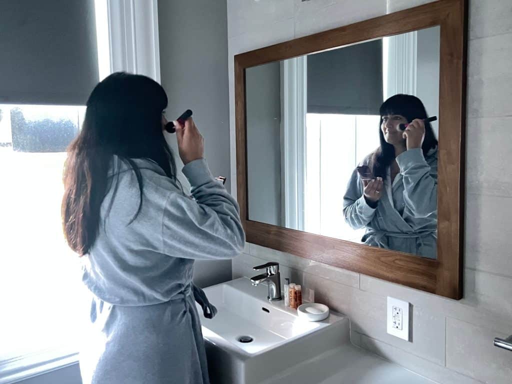 Bejal putting on make-up in Loft Suite bathroom
