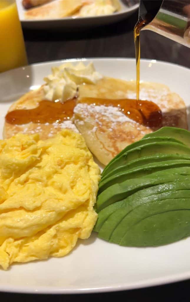 scrambled eggs, pancakes with maple syrup and avocado at The Buttery